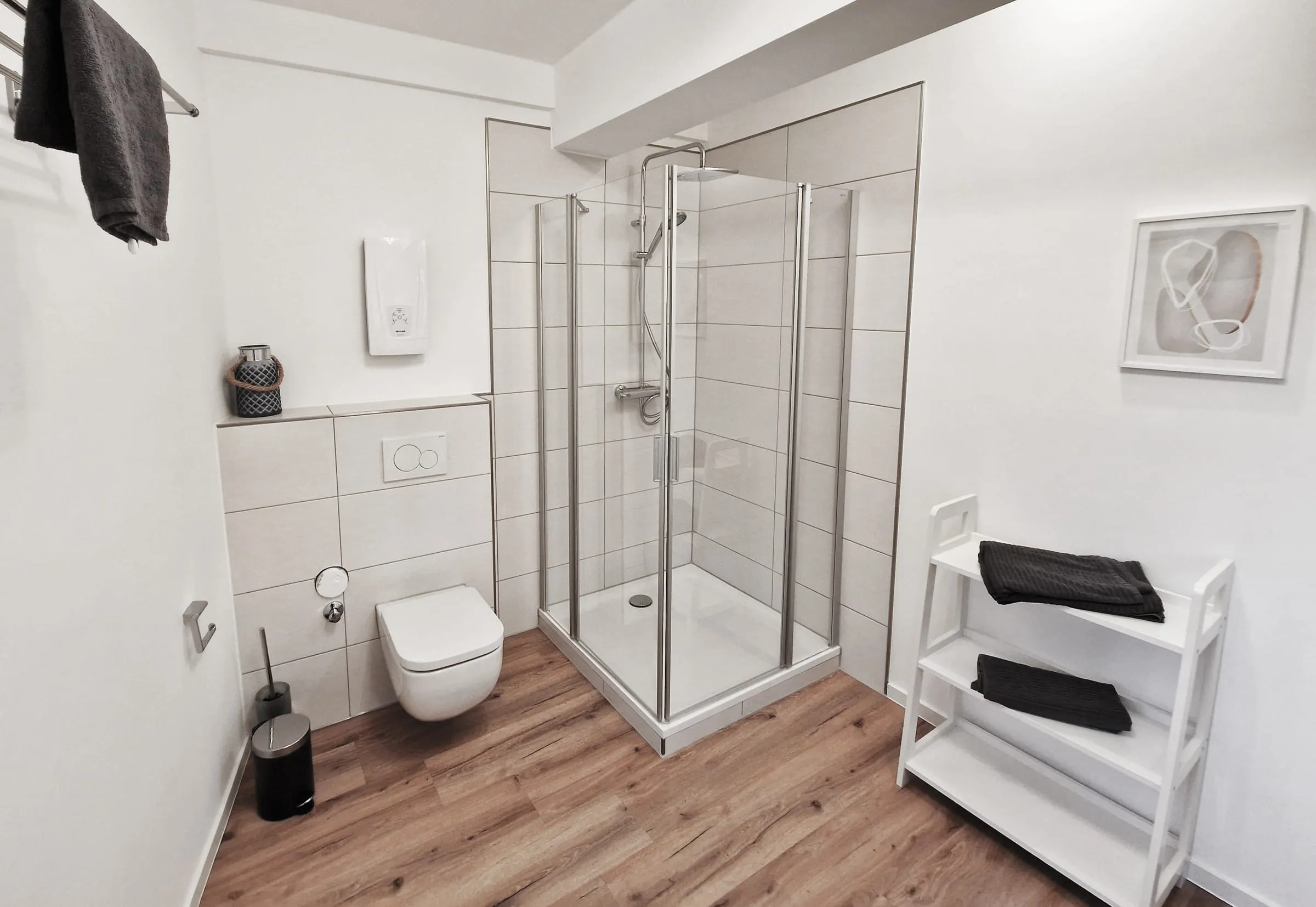 Eigenes Bad im Premiumzimmer mit Dusche, WC und Regal für Handtücher