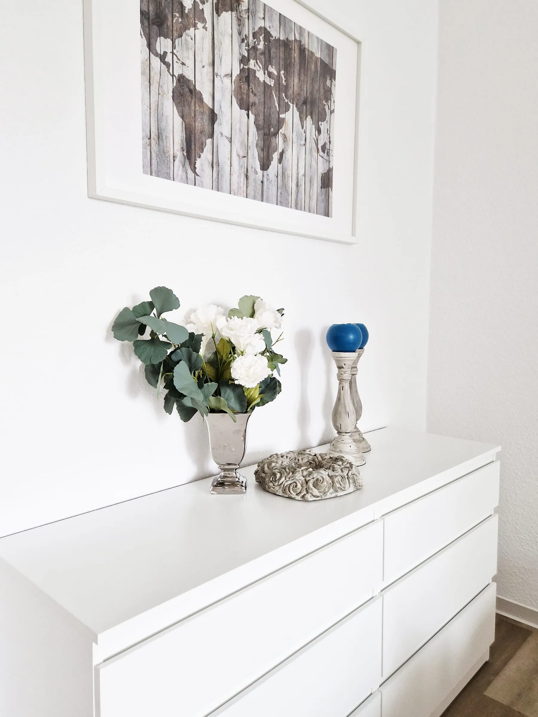 Dekoration auf der Kommode im Doppelzimmer mit Blumen und Kerzenständer