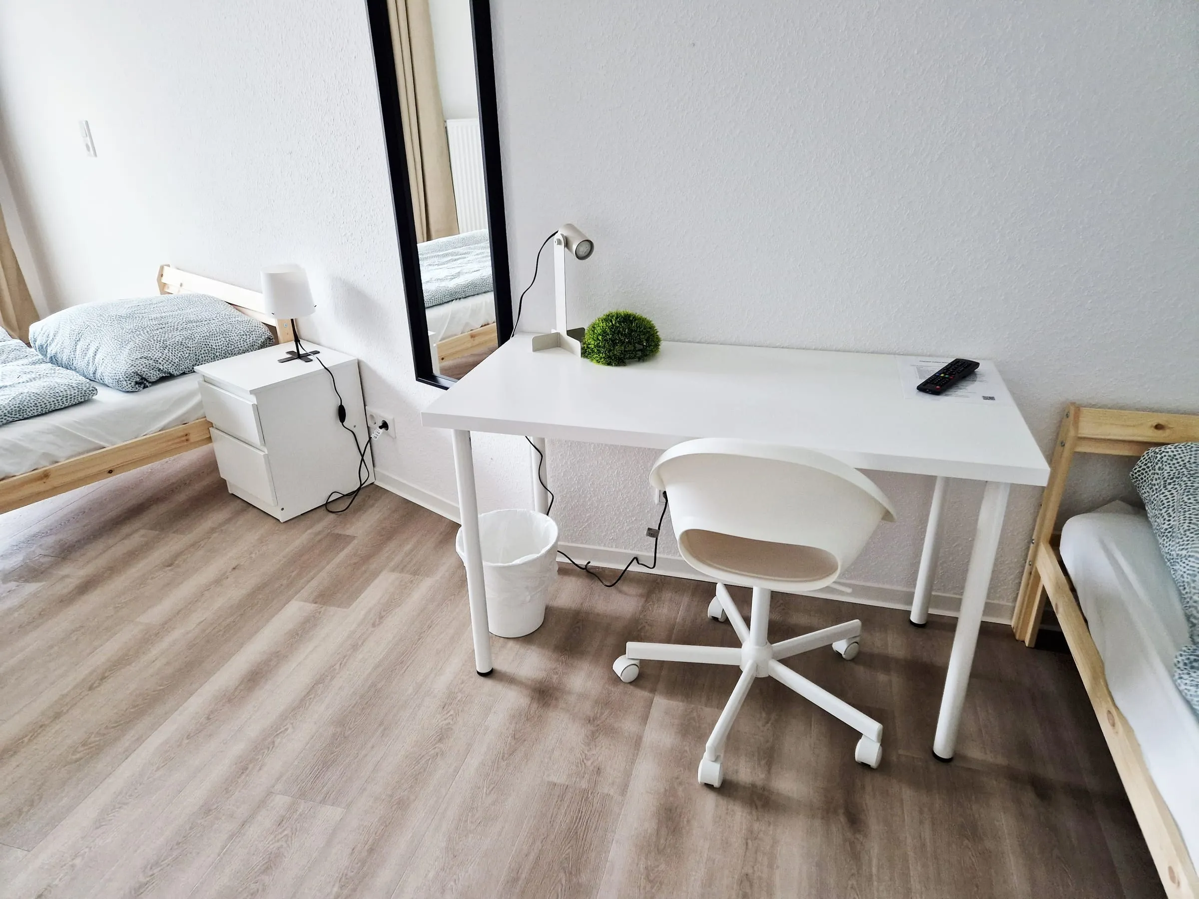 Schreibtisch mit Bürostuhl und Leselampe im Dreibettzimmer