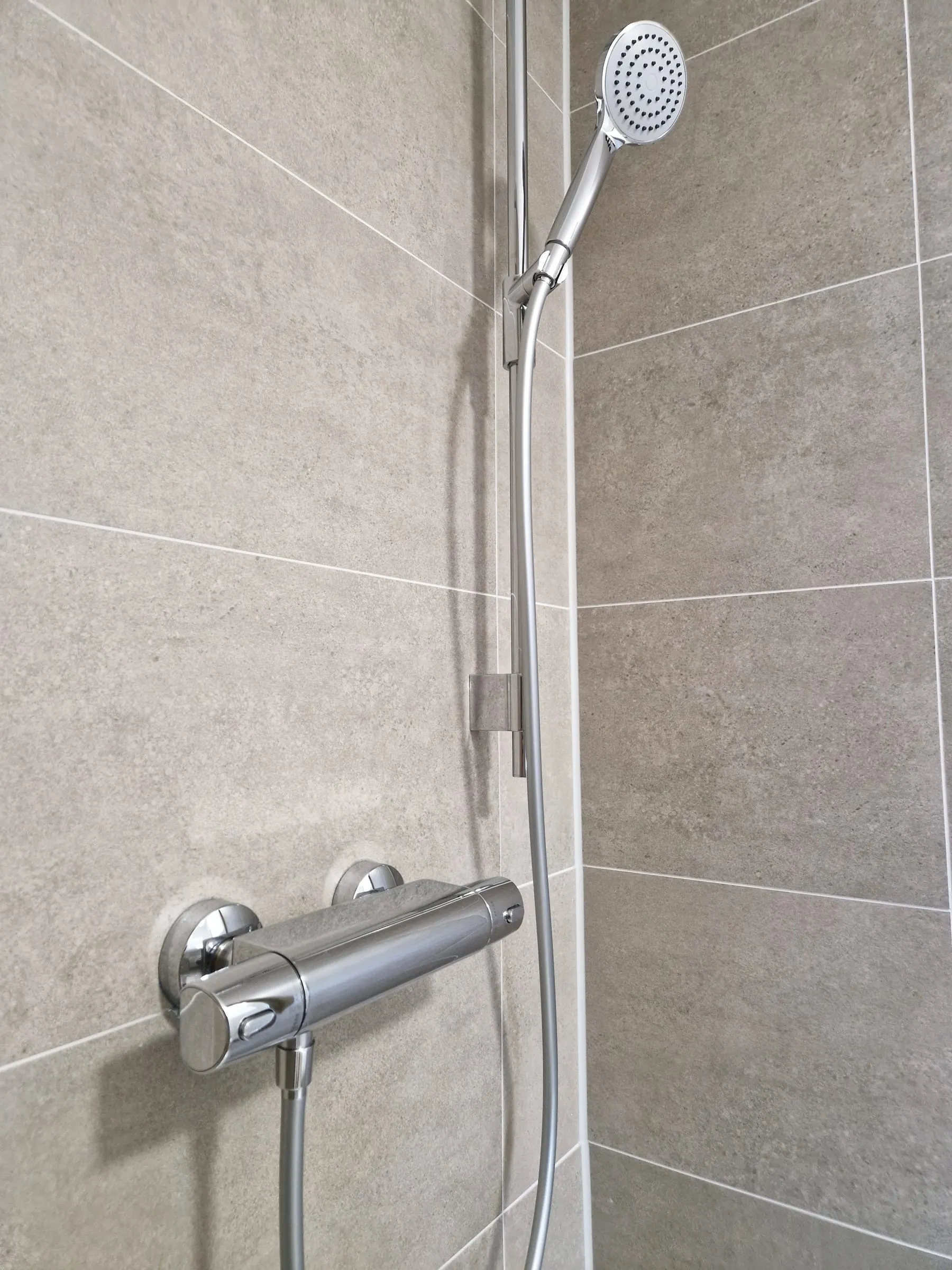 Thermostat-Armatur der Dusche im Bad des Dreibettzimmers