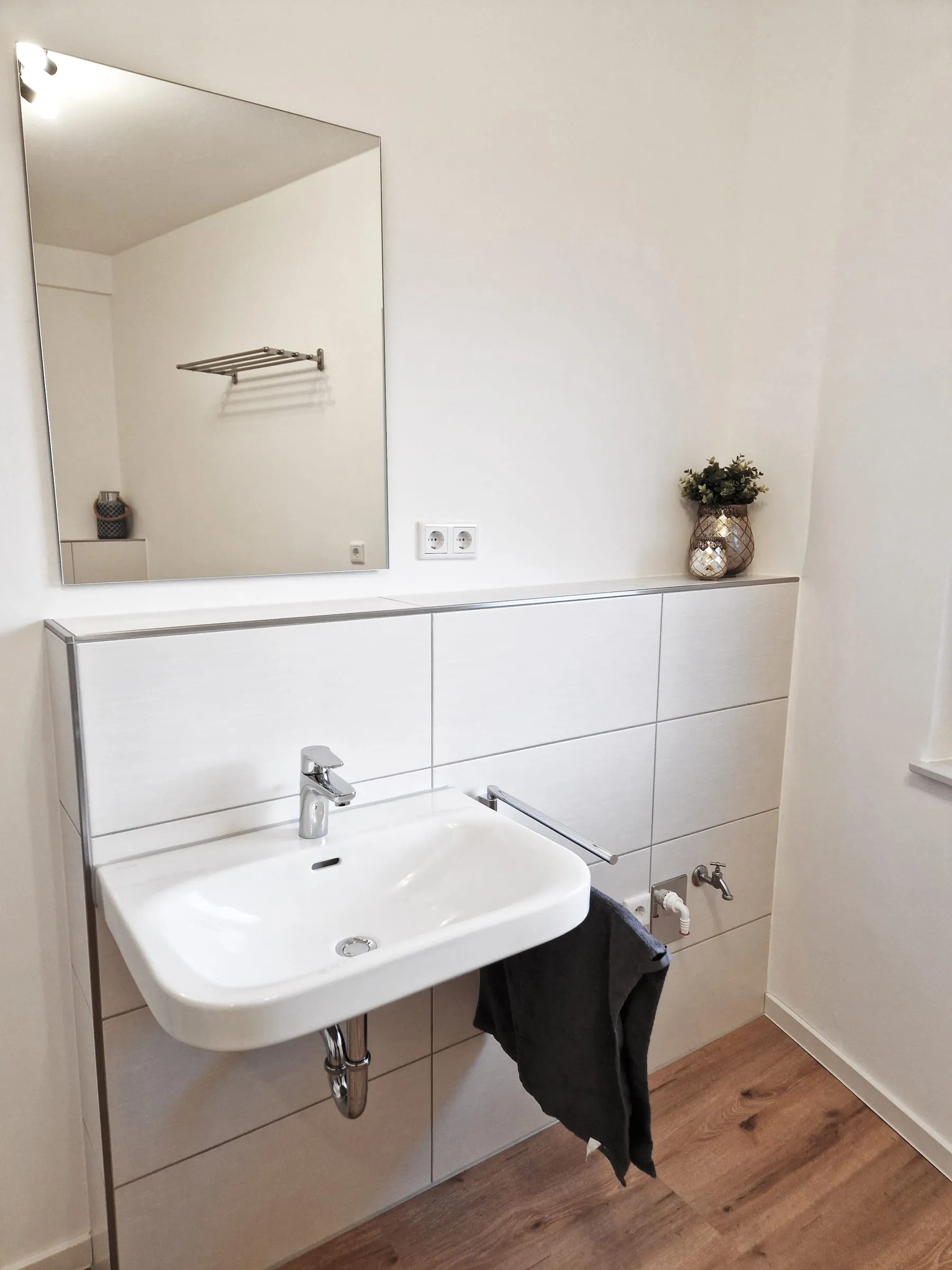 Waschbecken mit Spiegel und Ablage im Bad des Premiumzimmers